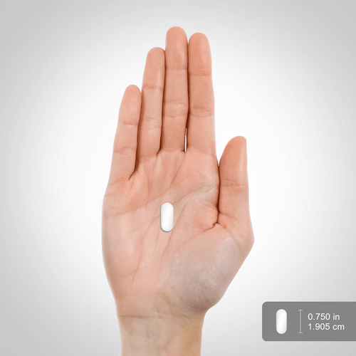 Hand holding a white pill with measurement indicators on a gray background