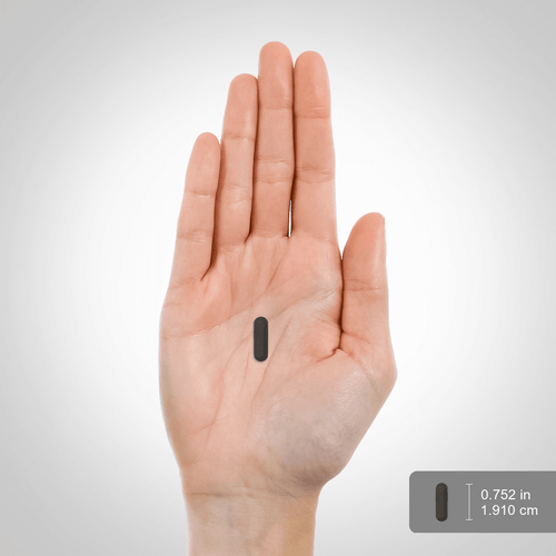Hand holding a small black rectangular object with measurement label on a white background